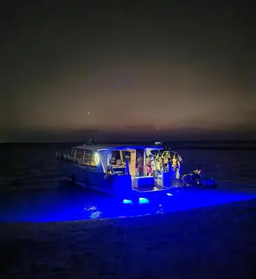 a boat with people on it on the water at night at Yacht Experience - Stella Romana in Dubai
