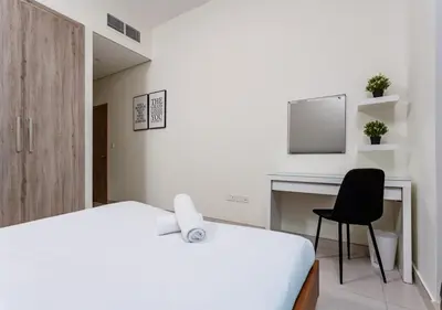 a bedroom with a bed and a desk and a chair at Spacious 1BR with Balcony & Rooftop Pool The Bay Business Bay in Dubai