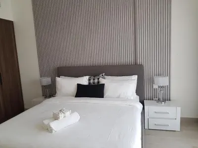 a bedroom with a white bed with towels on it at Stylish 1 Bedroom Apartment Near Burj Al Arab (Madinat Jumeirah) in Dubai