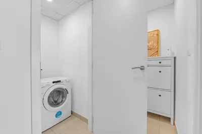 a white laundry room with a washer and dryer at Stylish 1 Bedroom Apartment Near Burj Al Arab (Madinat Jumeirah) in Dubai