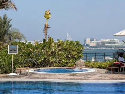 a child in a swimming pool at a resort at Fantastic flat in TiaraResidence in Dubai