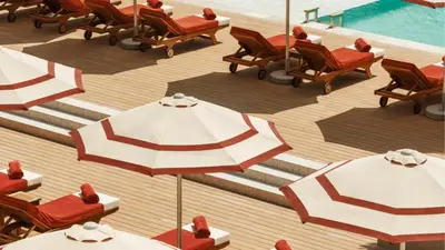 an overhead view of chairs and umbrellas next to a pool at Jumeirah Residences Marsa Al Arab Dubai in Dubai