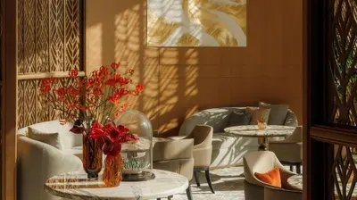 a room with two tables and chairs with red flowers at Jumeirah Marsa Al Arab Dubai in Dubai