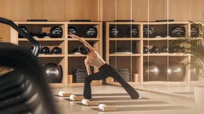 a woman doing a yoga pose in a room with wine bottles at Jumeirah Marsa Al Arab Dubai in Dubai