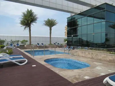a pool in front of a building with palm trees at Frank Porter - Goldcrest Views 2 in Dubai