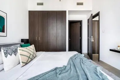 a bedroom with a large bed with a wooden headboard at GuestReady - Modern home with stunning city views in Dubai