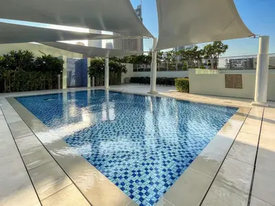 a swimming pool with an umbrella on top of a building at GuestReady - Modern home with stunning city views in Dubai