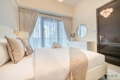 a bedroom with a white bed and a large window at Graceful 1BR at Merano Business Bay by Deluxe Holiday Homes in Dubai