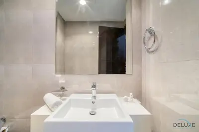 a bathroom with a white sink and a mirror at Graceful 1BR at Merano Business Bay by Deluxe Holiday Homes in Dubai
