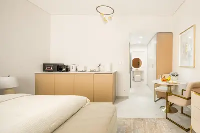 a bedroom with a bed and a small kitchen at Happy ACADEMIA JBR in Dubai