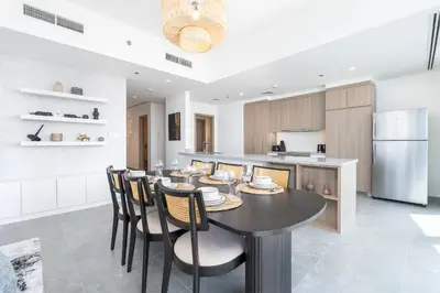 a kitchen and dining room with a table and chairs at Urban tropic 3 bedroom apartment with full sea view by Suiteable Interiors in Dubai