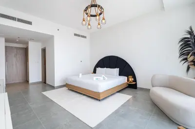 a bedroom with a bed and a couch at Urban tropic 3 bedroom apartment with full sea view by Suiteable Interiors in Dubai