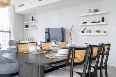 a dining room with a table with wine glasses at Urban tropic 3 bedroom apartment with full sea view by Suiteable Interiors in Dubai