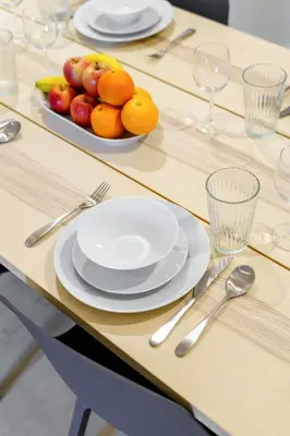 a table with plates and a bowl of fruit on it at Bright & Vibrant 2BR+kids room 7min to Dubai Mall in Dubai