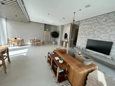 a living room with a couch and a flat screen tv at Luxury 1 Bedroom Sea View and Infinity Pool in Dubai