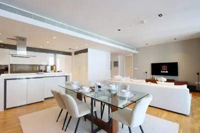 a dining room with a glass table and white chairs at High-End 1BR Bluewaters Luxury Near Ain Dubai in Dubai
