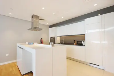 a kitchen with white cabinets and a sink at High-End 1BR Bluewaters Luxury Near Ain Dubai in Dubai