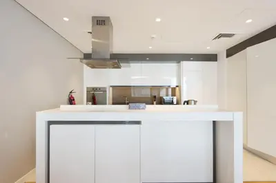 a kitchen with white cabinets and a ceiling at High-End 1BR Bluewaters Luxury Near Ain Dubai in Dubai