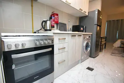 a kitchen with a stove and a washing machine at Exceptional Furnished Studio in Dubai
