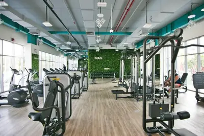 a gym with cardio equipment and people exercising in the gym at Exceptional Furnished Studio in Dubai