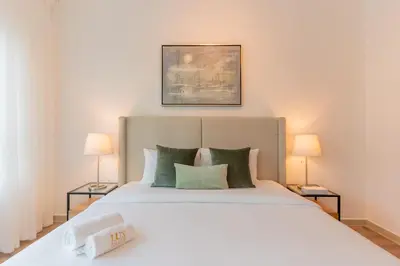 a bedroom with a large white bed with two lamps at Stylish Waterfront 2 Bed in Dubai Marina in Dubai