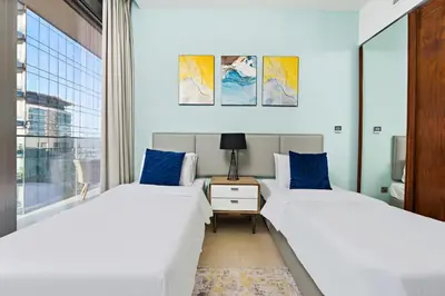 two beds in a room with a window at StoneTree - Marina Gate 2 BR - Partial Sea View in Dubai