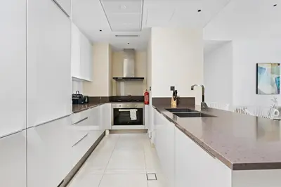 a kitchen with white cabinets and a counter top at StoneTree - Marina Gate 2 BR - Partial Sea View in Dubai