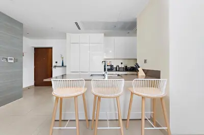 a kitchen with two chairs and a kitchen counter at StoneTree - Marina Gate 2 BR - Partial Sea View in Dubai
