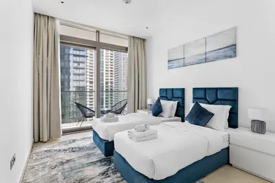 two beds in a hotel room with a window at StoneTree - Marina Gate 2 BR - Prime location in Dubai