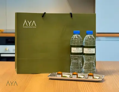 two bottles of water in a green bag on a table at Fancy One Bedroom Apartment in Downtown Dubai By ĀYA Boutique in Dubai