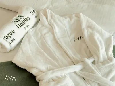 a white blanket and two pillows on a bed at Fancy One Bedroom Apartment in Downtown Dubai By ĀYA Boutique in Dubai