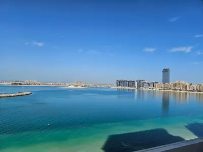 a large body of water with a city in the background at Vacay Lettings - Private Beach Access -Emaar Beachfront in Dubai
