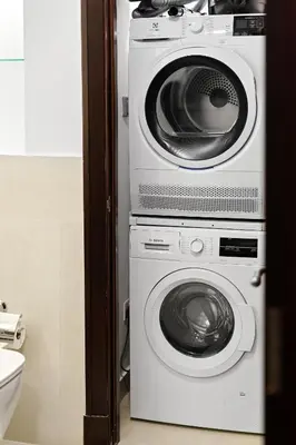 a washing machine and a dryer in a bathroom at Classy Design 2BR in Old Town w/ Burj Khalifa View in Dubai