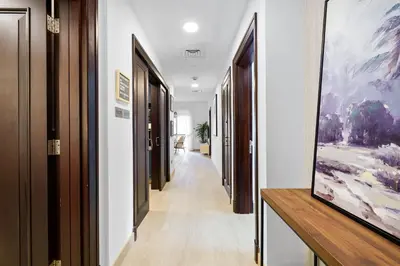 a hallway with white walls and a painting on the wall at Classy Design 2BR in Old Town w/ Burj Khalifa View in Dubai