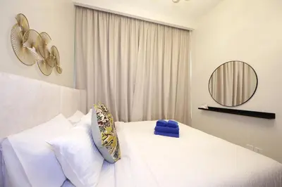 a bedroom with a white bed and a mirror at New Arabian Reva 1BR Burj Khalifa View in Dubai