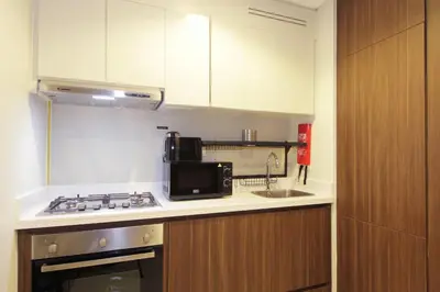 a small kitchen with a stove and a microwave at New Arabian Reva 1BR Burj Khalifa View in Dubai