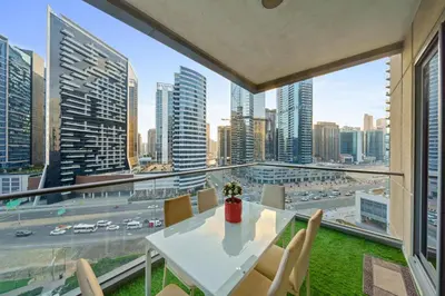 a table and chairs on a balcony with a view of a city at Contemporary & Roomy 2BR with Burj Khalifa view in Dubai