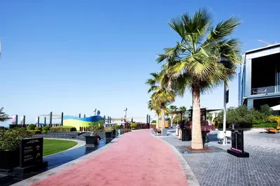 a red walkway with palm trees in a park at New sea view Rimal 2BD in front of the beach in Dubai