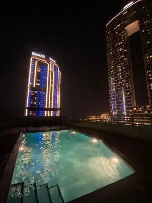 a swimming pool on the roof of a building at night at Stylish 1 BR with sea view - Sunset view in Dubai