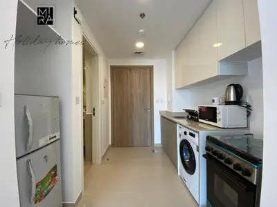 a kitchen with a washer and dryer in a room at Mira Holiday Homes - Serviced Studio in Una Apartment in Dubai