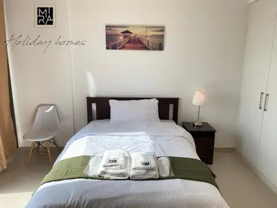 a bedroom with a bed with two towels on it at Mira Holiday Homes - Serviced Studio in Una Apartment in Dubai