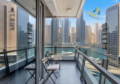 a balcony with a table and chairs and a view of the city at One Bed in Dubai Marina with Marina Views, Hosted by Desert City Stays in Dubai