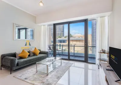 a living room with a couch and a large window at One Bed in Dubai Marina with Marina Views, Hosted by Desert City Stays in Dubai