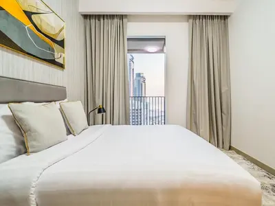 a large white bed in a room with a window at Incredible Waterfront Apt with Panoramic Views in Dubai