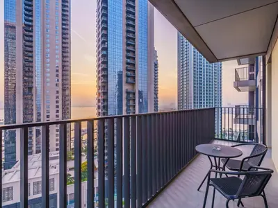 a balcony with a table and chairs and buildings at Incredible Waterfront Apt with Panoramic Views in Dubai