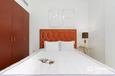 a bedroom with a large bed with a wooden headboard at Dream Inn Apartments - Sadaf Residence JBR in Dubai