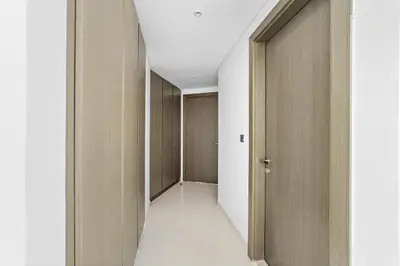 a hallway with wooden doors and a white floor at Elegant 1BR - Spacious & Luxury - Canal View in Dubai