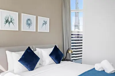 a bedroom with a bed with blue and white pillows at Elegant 1BR - Spacious & Luxury - Canal View in Dubai
