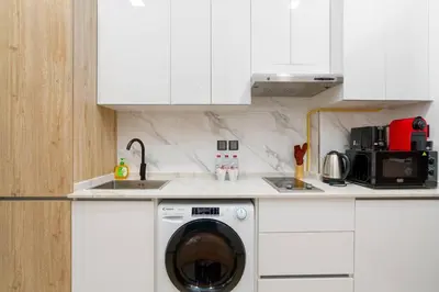 a kitchen with a washing machine in a sink at Nice and cozy Studio Elysée 2 in JVC - Dubai in Dubai