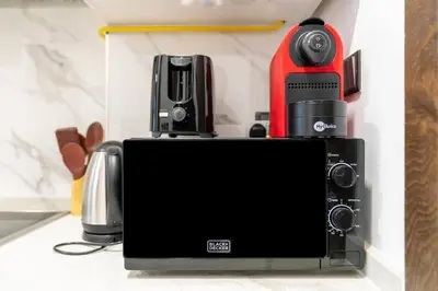 a coffeemaker with a coffee maker on top of it at Nice and cozy Studio Elysée 2 in JVC - Dubai in Dubai